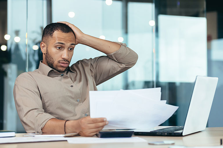 Frustrated man looking at a resume.